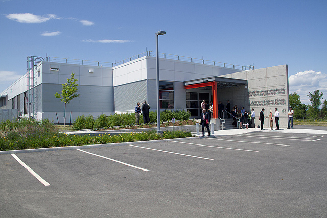 Colour photograph of the exterior of a building. Front: Parking lot area; Back: Main entrance to the building