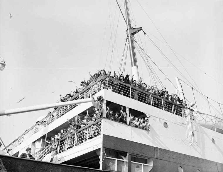 War brides, en route to Canada aboard S.S. Letitia, waving goodbye to families and friends.