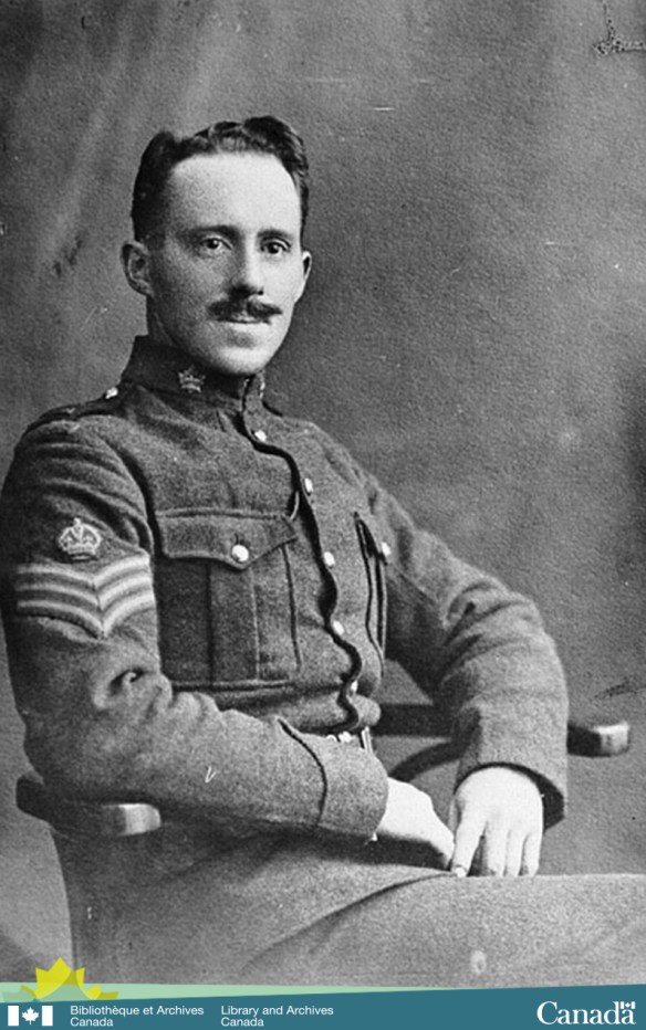 Black-and-white photograph of a young soldier, in military uniform, with a moustache sitting in a chair.