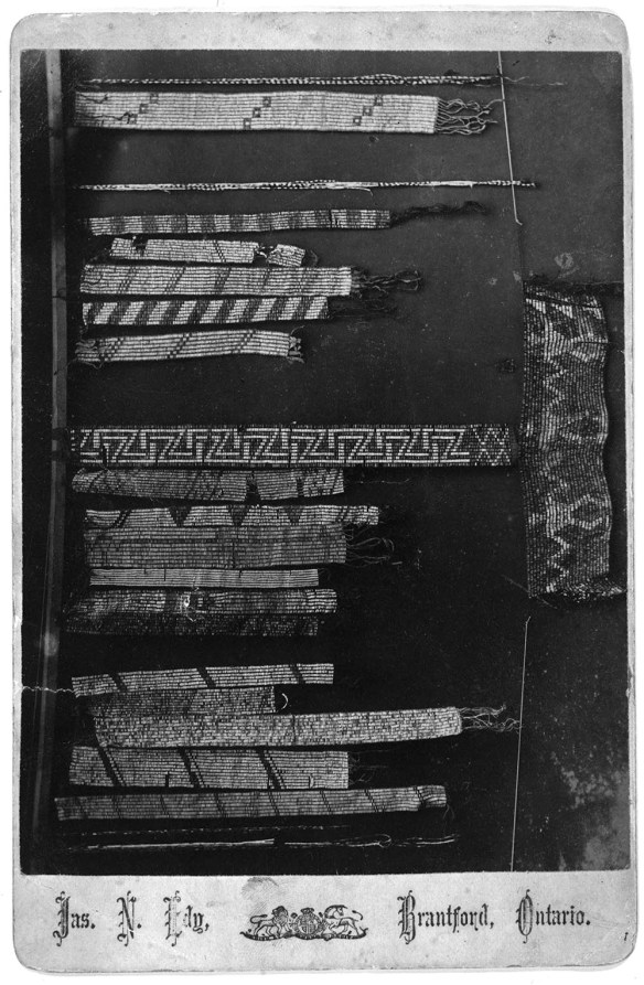 Black-and-white photograph showing several different kinds of wampum belts and strings.