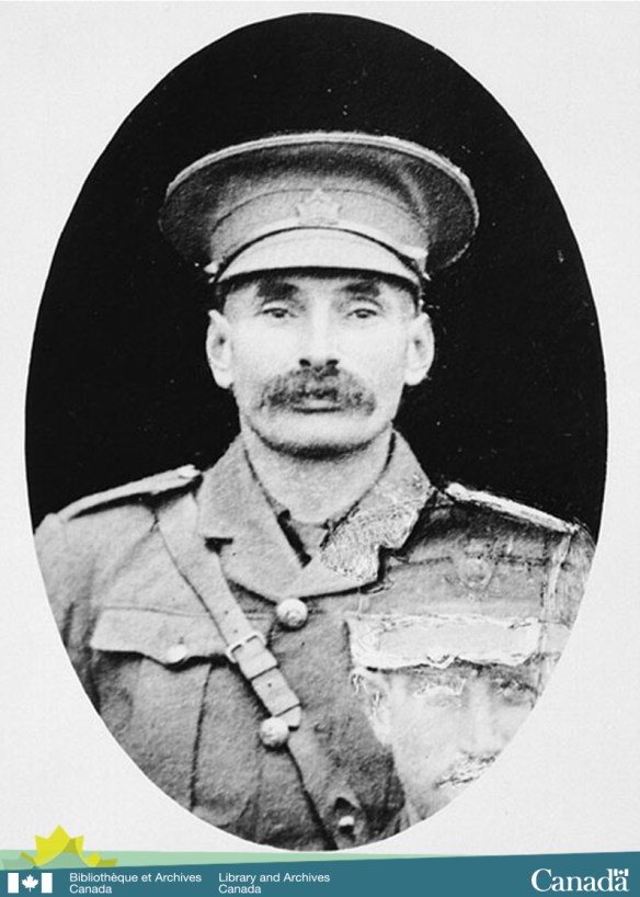 Black and white photograph of a man in uniform looking directly at the camera 