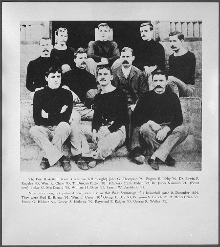 A black-and-white photograph of a group of men sitting on a staircase. On each side are the baskets that were first used in the sport.