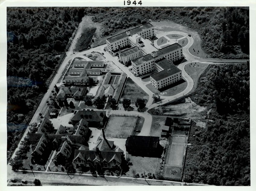 A black-and-white aerial view of a building complex.