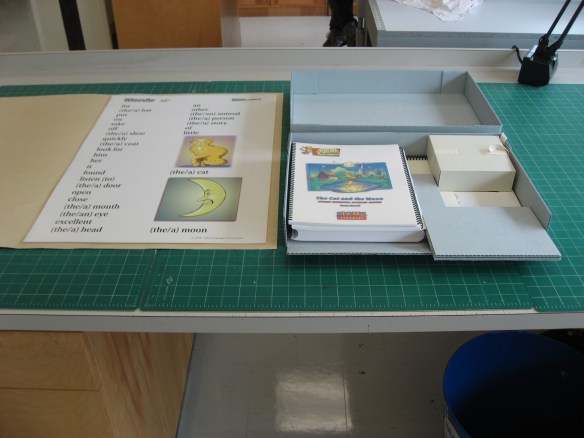 A colour photograph of a custom container and a custom folder for a poster.