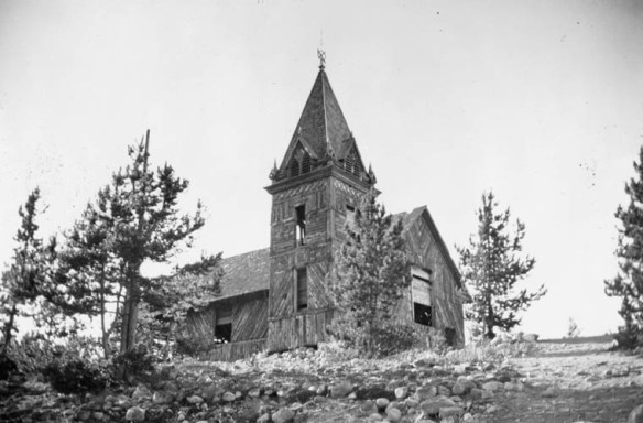 A black-and-white photograph of an abandoned wooden church