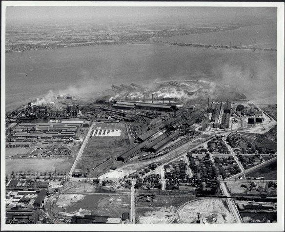 Black and white photograph showing an industrial complex for steel production and processing. 