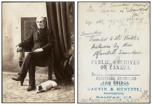 Black-and-white photograph of a middle-aged man sitting in an ornate chair with a small dog, possibly a Russell terrier, laying at his feet. The man is wearing a black clerical suit. Dark drapery and a potted plant appear in the right of the portrait. The back of the photograph includes a stamp from Gauvin & Gentzel Studio. 