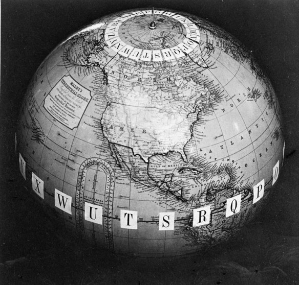 A black-and-white photograph of a terrestrial globe showing the North American continent with letters at each meridian around the North Pole and at the equator.