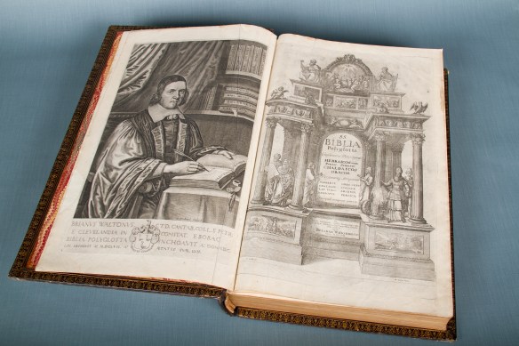 A colour photograph of an open book on a blue background showing a very well dressed man on the verso and an elaborately illustrated frontispiece on the recto.