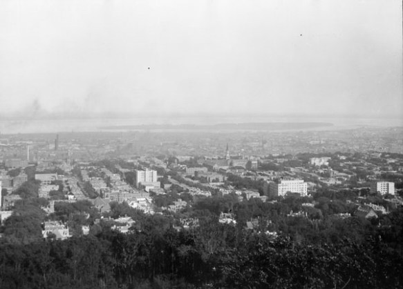 A black-and-white photograph of a bird’s eye view of a city.