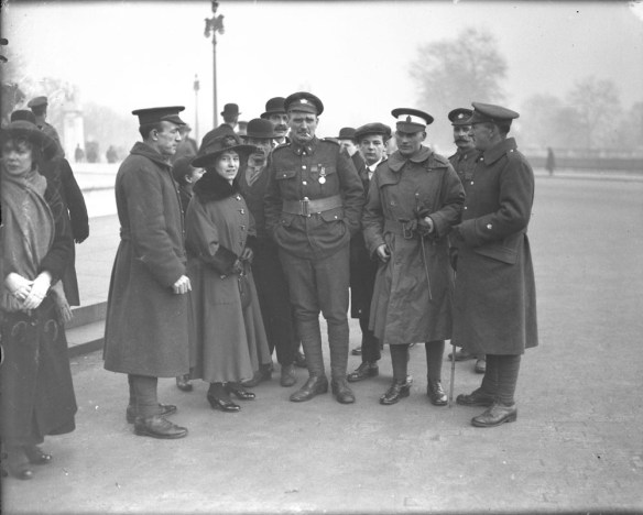 A black-and-white photograph of a group of people gathered around two soldiers.