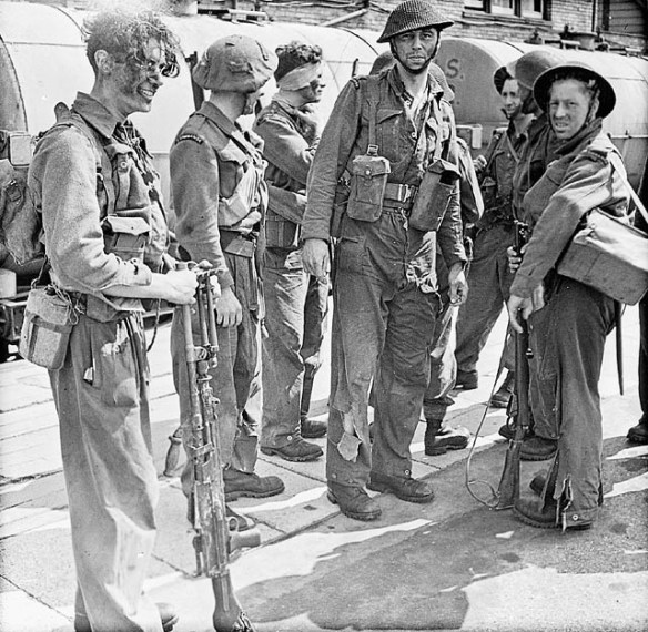 A black-and-white photograph of soldiers, some wounded or with torn uniforms.