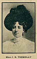 A black-and-white photograph of a young woman wearing a very large hat.