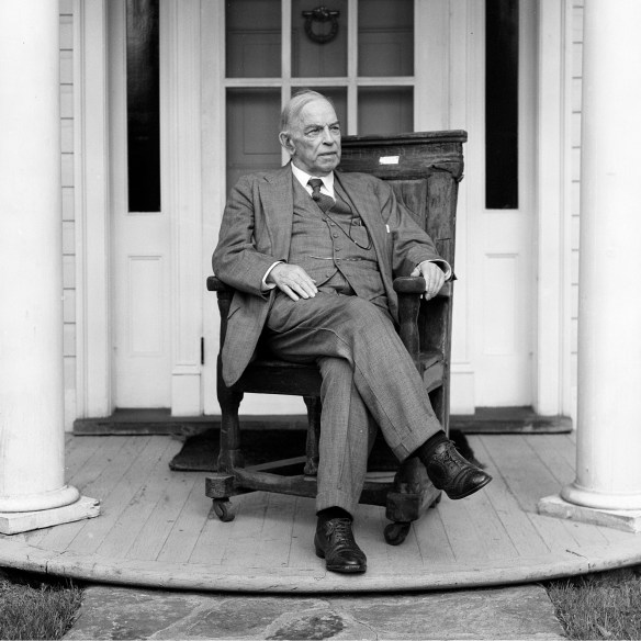 Black-and-white image of William Lyon Mackenzie King sitting on his front porch.