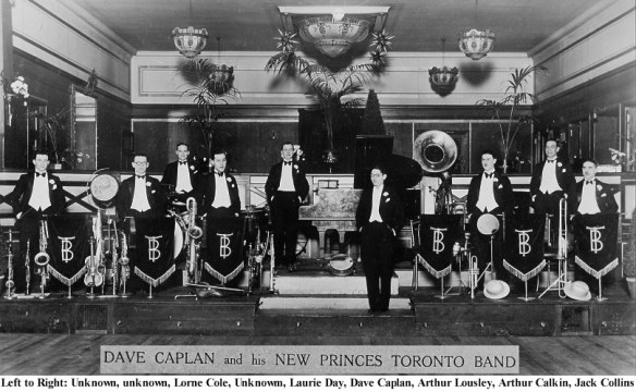 A black-and-white photograph of men dressed in formal wear standing with their musical instruments.
