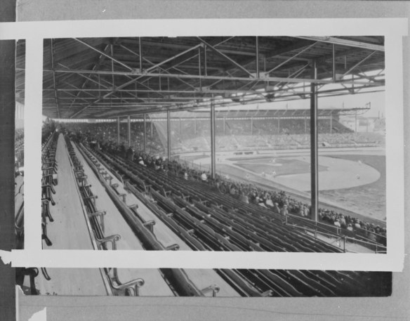 A black-and-white photograph of a baseball stadium, taken from the vantage point of the right field bleachers. The bleachers and the field, including the diamond and outfield, are visible.