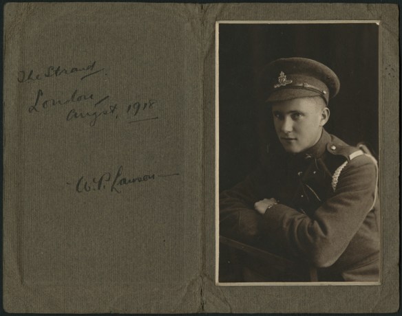A black-and-white studio portrait of a young man in uniform, with arms crossed.