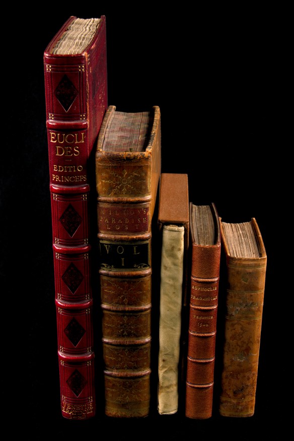 Colour photograph of a row of books: left to right: Euclid’s Elementa, 1482; Milton’s Paradise Lost, 1758; Relation de ce qui s’est passé en la mission des pères de la Compagnie de Iésus …, 1651; Sophocleos Tragoediai, 1502; The Lower-Canada Watchman, 1829.