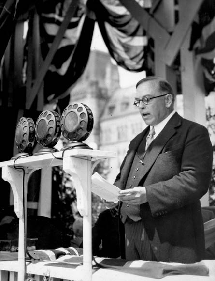 Black-and-white photograph of the Right Honourable William Lyon Mackenzie King, Prime Minister of Canada, speaking at the dedication of the Peace Tower carillon.