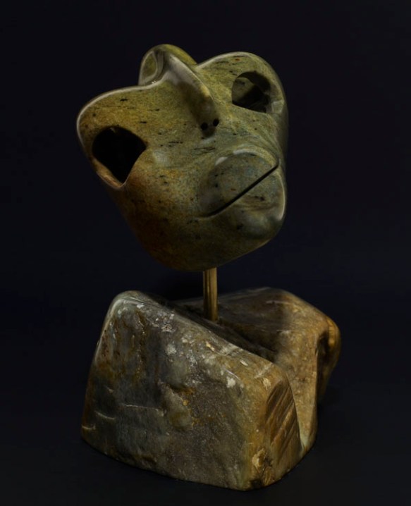 A colour photograph of the front of a stylized sculpture of a man with his head tilted to the side. 