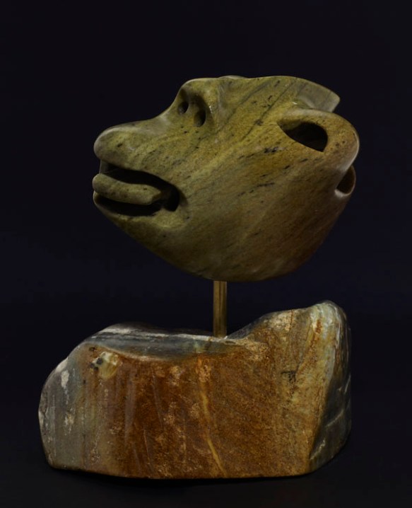 A colour photograph of the front of a stylized sculpture of a man sticking his tongue out.