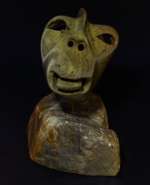 A colour photograph of the front of a stylized sculpture of a man with his tongue sticking out.