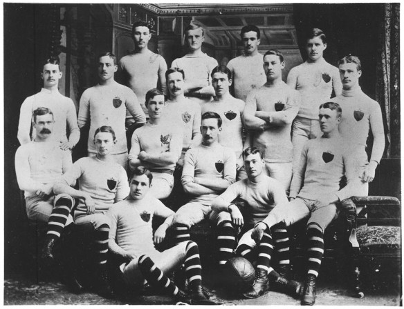 A black-and-white photograph of the McGill University rugby team, 1884-1885. James Naismith sits with his teammates (far-left of the second row of four). 