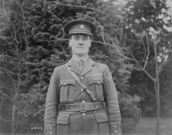 A black-and-white photograph of a smiling soldier in his service dress uniform.