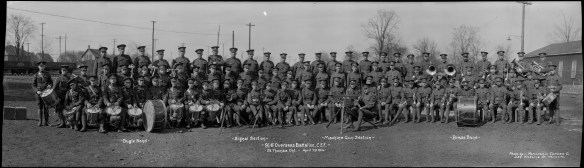 A panoramic photograph showing the soldiers of the 91st Overseas Battalion, Canadian Expeditionary Force, standing and sitting in three rows. The soldiers are dressed in uniform, some are holding drums and other musical instruments.