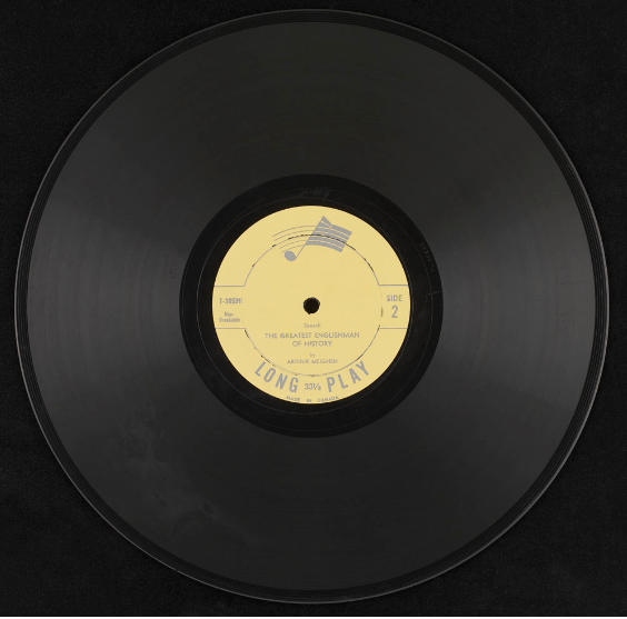 A black 12-inch vinyl record with a yellow label. 