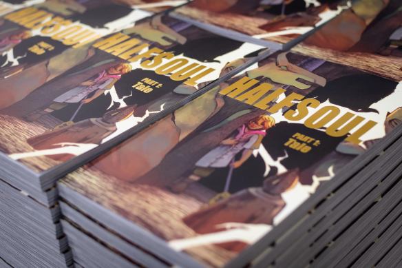 A coloured photograph of stacks of the graphic novel Halfsoul.