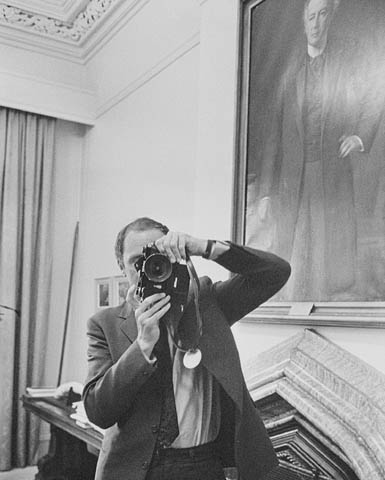 Black-and-white photo of a man taking a photograph of a photographer who is photographing him.