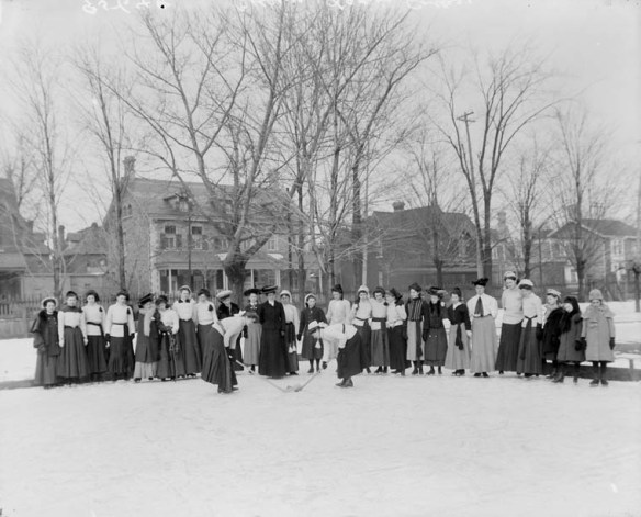 A black and white photo taken outside with women in long skirts.