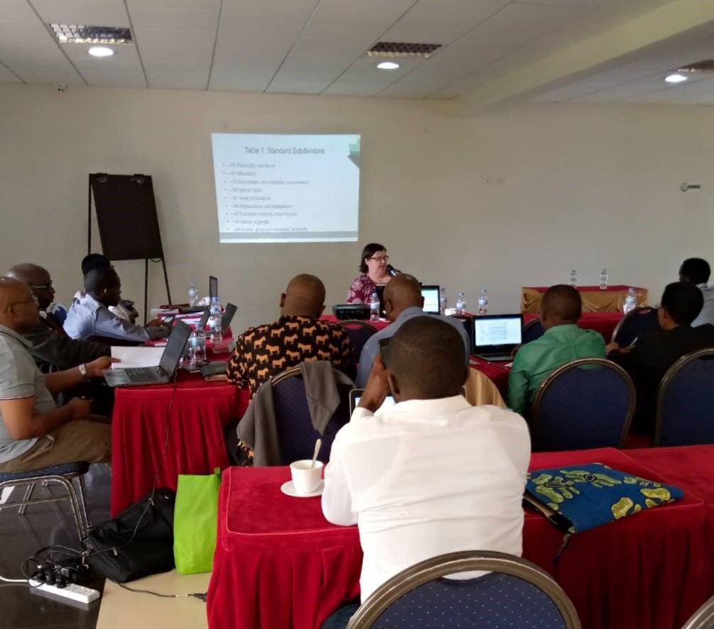 A colour photo of people gathered in a conference room.