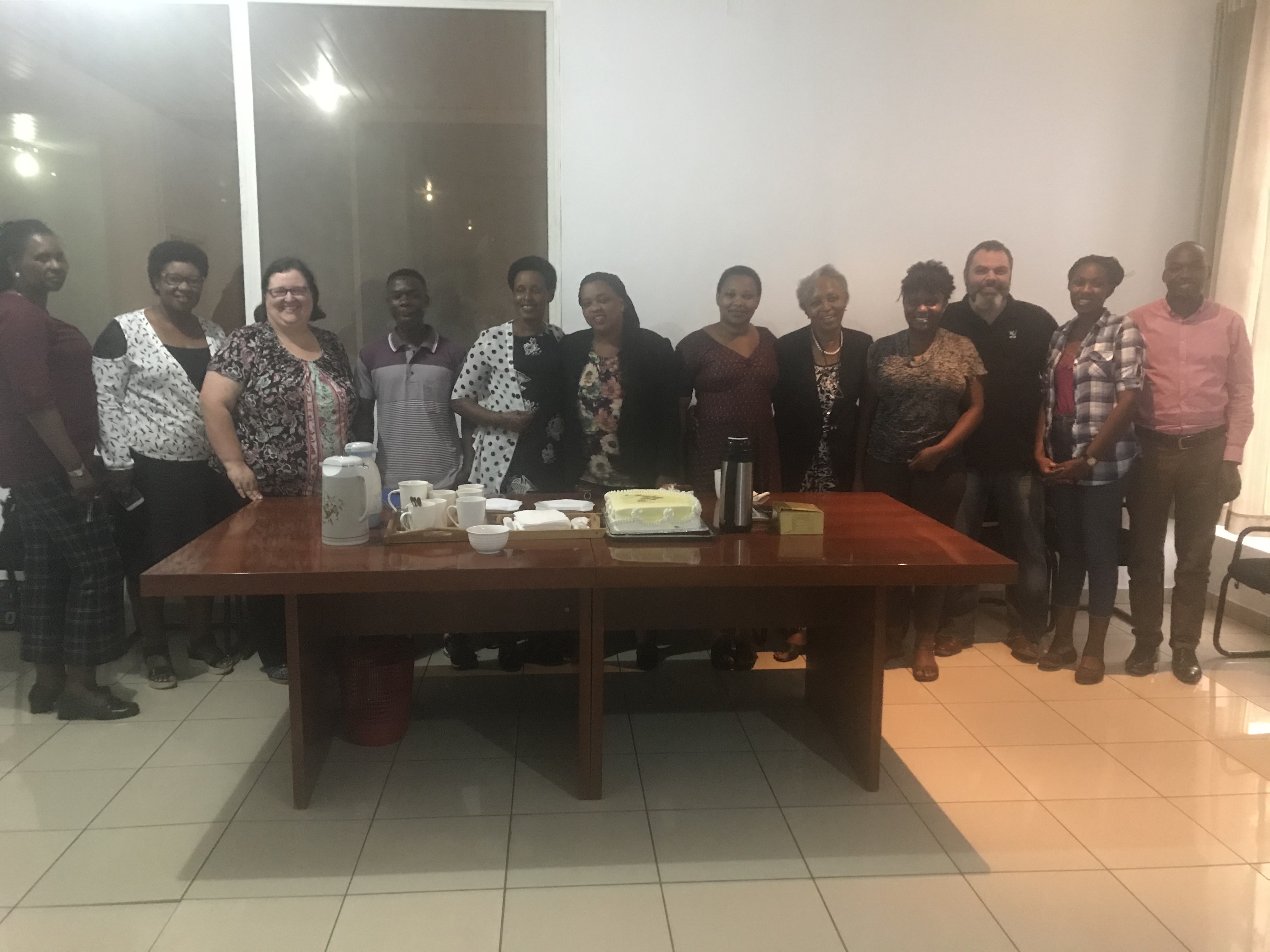 A colour photo of a group of people gathered around a table.
