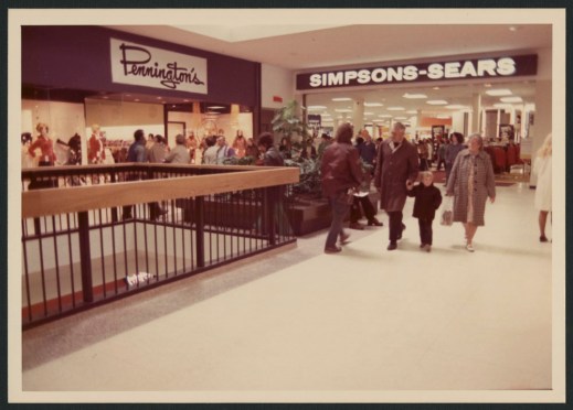 The interior photograph shows shoppers on the upper floor of the mall with “Pennington’s” and “Simpsons-Sears” signs in the background.