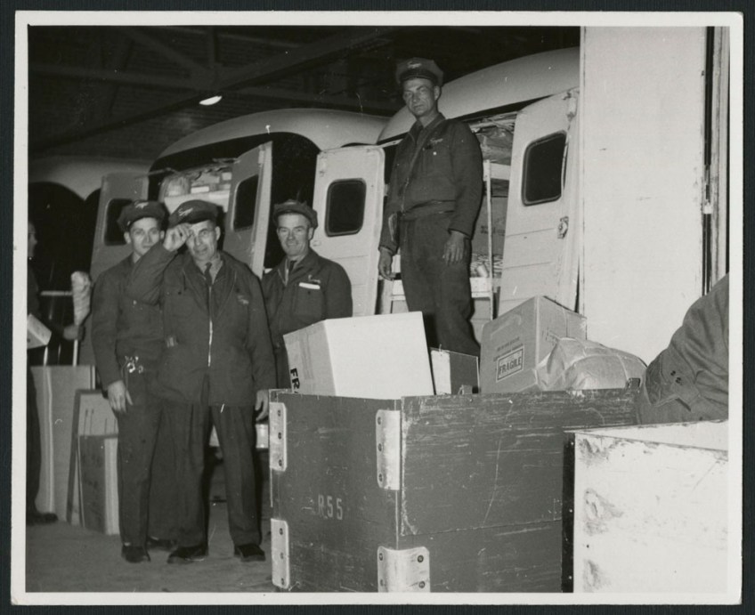 Three black-and-white photographs showing men dressed in uniforms beside Simpson’s delivery trucks, over the decades.