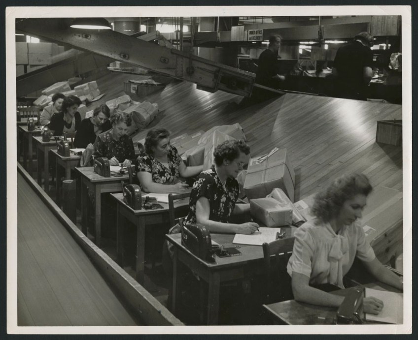 Two black-and-white photographs, one showing a group of employees sorting parcels into bins, and the other showing women at desks checking addresses on parcels as the parcels slide down a ramp toward them.