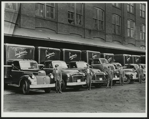 Three black-and-white photographs showing men dressed in uniforms beside Simpson’s delivery trucks, over the decades.