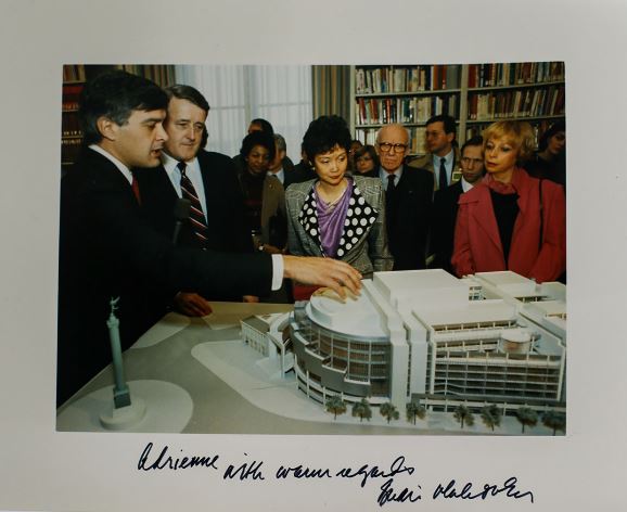 Several people looking at a model of a building.