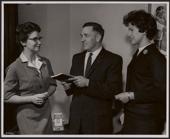 A black-and-white photograph of two women and a man in business attire.