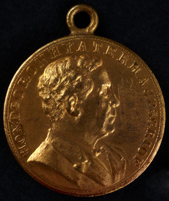 Medallion of a right-side profile of Dr. Oronhyatekha including an image of the Temple Building in Toronto.