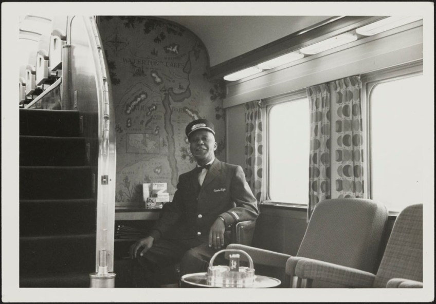 Canadian Pacific Railway sleeping car porter sitting in a train wagon.