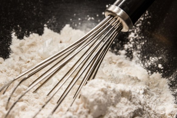 Dry ingredients from the recipe being mixed with a whisk.