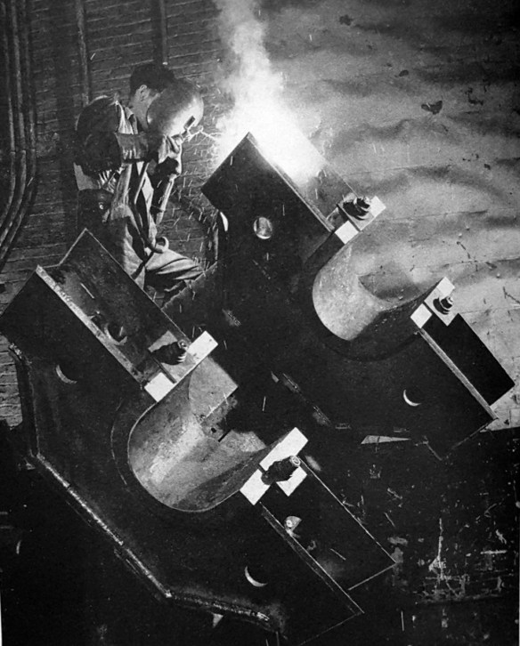 A person welding a large piece of metal.