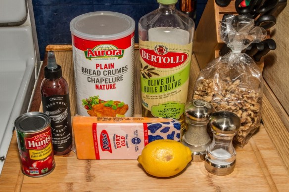 Ingredients used for the cheese and walnut loaf recipe: tomato paste, hot sauce, cheddar cheese, breadcrumbs, olive oil, lemon, pepper, salt and walnuts. (The onion is not in the photo.)