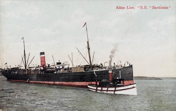 Colour photograph of a ship with black sides and a red strip across the bottom and a red, black, and white smokestack. There is a smaller white boat with four oars, and a smokestack emitting smoke anchored at the right front. The name of the ship is written in red typeset letters in the upper right corner of the image.