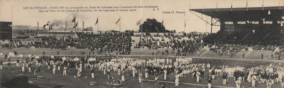 A black and white panoramic photograph of an outdoor stadium with hundreds of athletes.